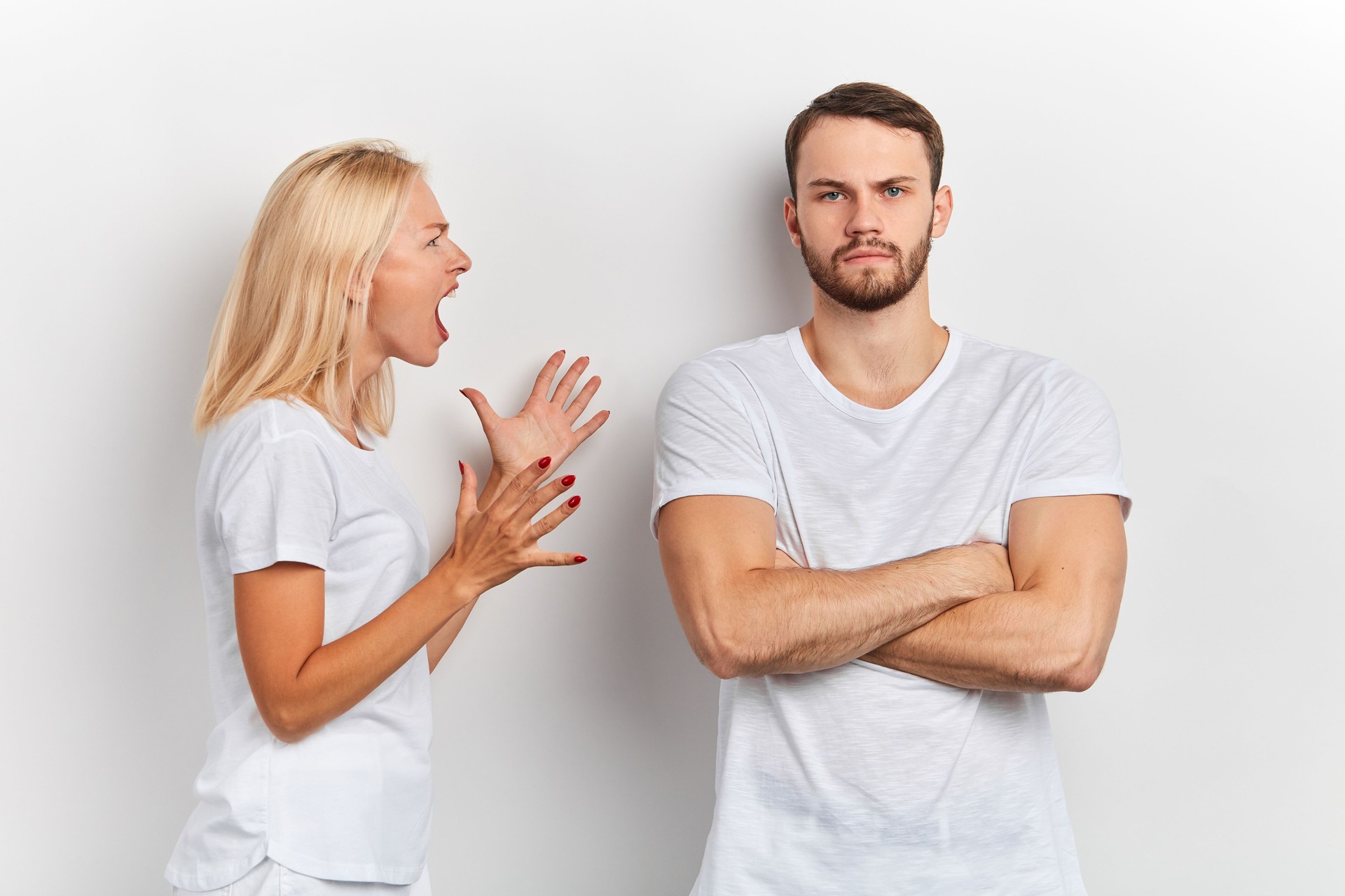 Angry frustrated women shouting at man who standing with crossed arms